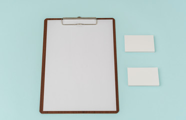 Clip board, paper and business card on blue background .