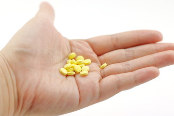 Fototapeta premium Yellow pill in hand.