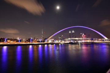 Naklejka na ściany i meble Dubai Skyline at night from new Dubai Canal, U.A.E