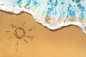 Sanfte Wellen mit schaumblauem Ozeanmeer an einem goldenen, sonnigen Sandstrand im Erholungsort im Sommerurlaub. Das Symbol der Sonne, die auf den Sand zeichnet. Hintergrund hautnah. © Laura Pashkevich