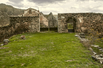 Fototapeta na wymiar Entrance door and gate to the stone wall surrounding medieval monastery