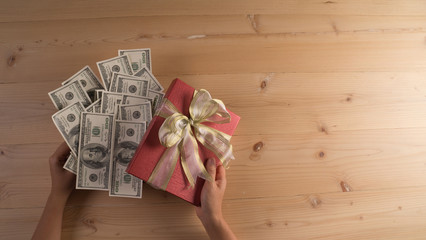Woman holding a gift box with a red box in the dollar.