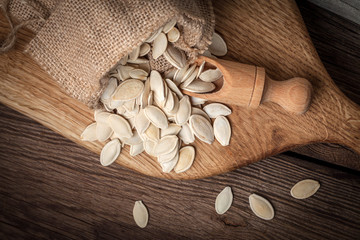 Pumpkin seeds in a sack and spoon.