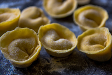 Making tortellini pasta from italian flour semolina, eggs, mushr