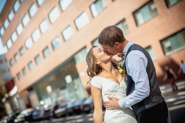 Happy bride and groom dancing on a street