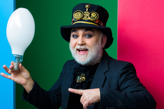 smiling man holds light bulb