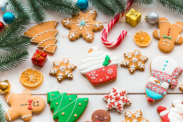 Christmas cookies with candy and  festive branches fir. Homemade delicious Christmas gingerbread cookies on the wooden background.
