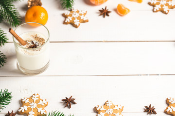 Christmas Gingerbreads with glass milk and festive branches fir. Homemade delicious cookies on the wooden background. Free space for your text.