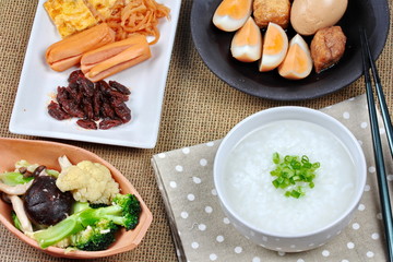 Closeup rice gruel with sausage, fried vegetables and stewed egg