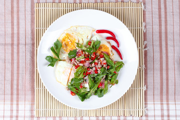 Thai food,Spicy wing bean with pork topped fried egg.