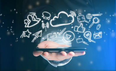 Hand of a man holding smartphone with internet icons all around