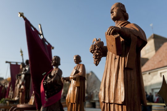 Wooden statues of patron saints during the annual festival of Saint Vincent Tournante (Turning St. Vincent), held in one of the wine producing villages in Burgundy, created in 1938 by the Confrerie des Chevaliers du Tastevin (Confraternity of the Knights 