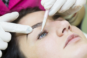 Woman on the procedure for eyelash extensions, eyelashes lamination