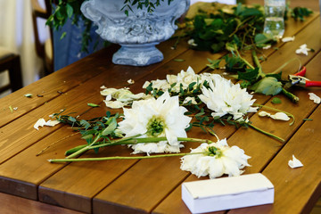 Cut white flowers lie on wooden table