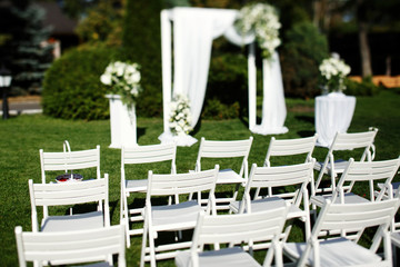 Look from behind at pretty garden chairs standing before gorgeou