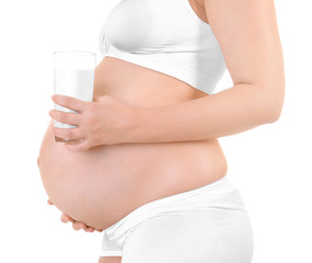 Pregnant woman holding glass of milk on white background, closeup