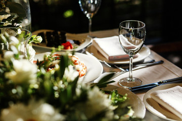 Empty wineglass stands before plates with salads