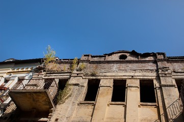 Abandoned uninhabited house with broken windows and overgrown with tree