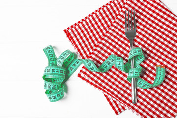 Fototapeta premium Fork and measuring tape on red napkin
