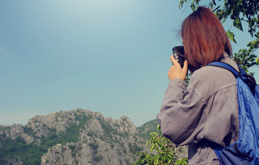 young girl with backpack taking photo of amazing landscape  on v