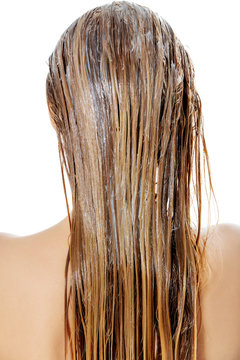 Photo of woman applying hair conditioner.