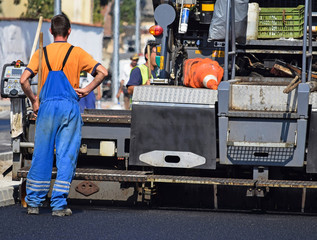 Road construction with an asphalt paving vehicle