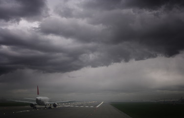 Fototapeta na wymiar Plane ready for take off and stormy skies, Heathrow Airport, London