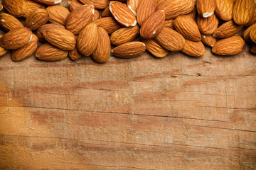Almendras naturales sobre fondo rústico de madera. Vista superior. Copy space