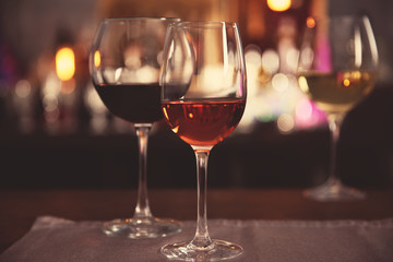 Two glasses with tasty wine in bar on bright background