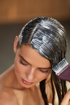 Hair Masks. Woman Applying Mask With Brush On Wet Long Hair