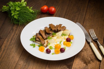 Sliced roast beef on toast, cheese, basil, berries, plum and Dutch sauce. Restaurant supply  a wooden background. Top view. Close-up
