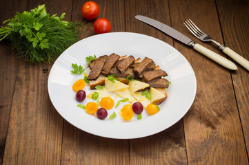 Sliced roast beef on toast, cheese, basil, berries, plum and Dutch sauce. Restaurant supply  a wooden background. Top view. Close-up