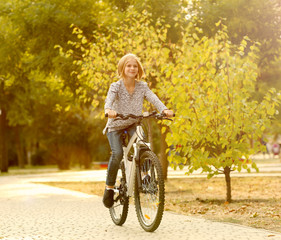 Cute girl riding bicycle in park