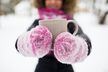 close up of woman with tea mug outdoors in winter