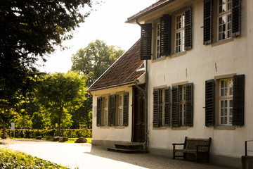 Fototapeta na wymiar Altes Haus mit Fensterläden in einem Park im Münsterland