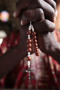 African man praying the rosary, Cotonou, Benin, West Africa