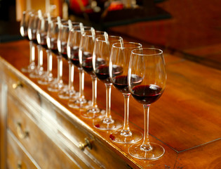 Row of glasses with red wine on bar counter