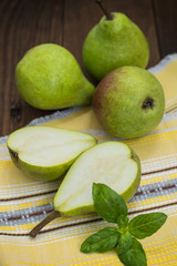 Ripe pears in a basket on  wooden background. Top view. Close-up