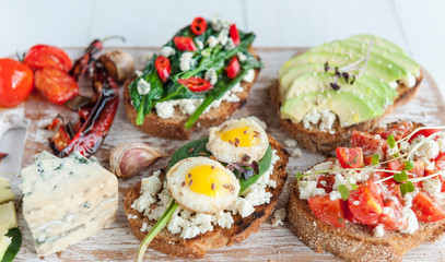 tasty and delicious bruschetta with with vegetables, cheese and micro greens
