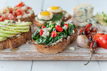 tasty and delicious bruschetta with with vegetables, cheese and micro greens