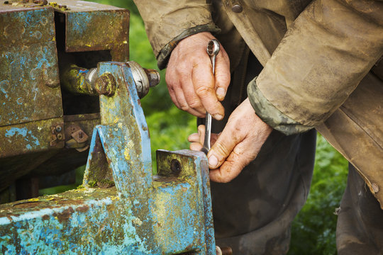Man using spanner on farm machinery