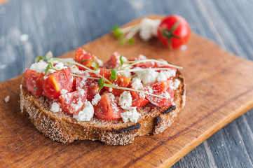 tasty and delicious bruschetta with with vegetables, cheese and micro greens
