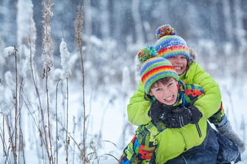 cheerful happy boys playing in winter park,