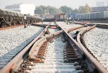 Train tracks in Thailand with blurred train car in background.