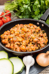 Squash caviar on a frying pan. Wooden rustic background. Top view. Close-up