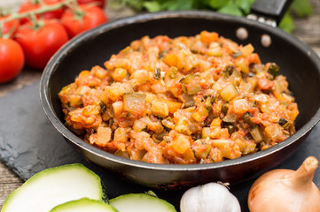 Squash caviar on a frying pan. Wooden rustic background. Top view. Close-up