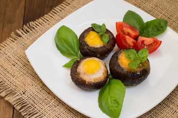 Stuffed champignon quail eggs with basil and tomatoes. Wooden background. Close-up