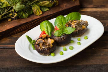 Stuffed champignon quail eggs with basil and tomatoes. Wooden background. Close-up