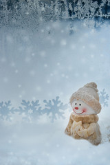 Christmas snowman on snow winter blue background with snowflakes.