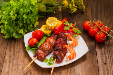 Skewers of smoked salmon on  with prawns and vegetables
